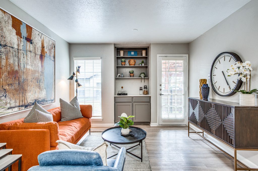 a living room with a large clock and orange couch at The Richmond