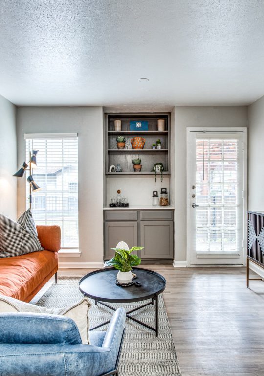 a living room with a large clock and orange couch at The Richmond